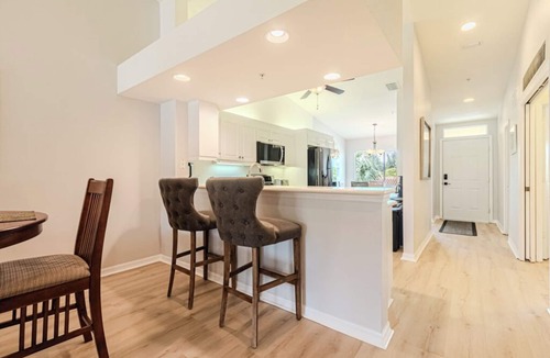 Naples Condo | Relax on the oversized lanai featuring an outdoor kitchen and mid-water view.